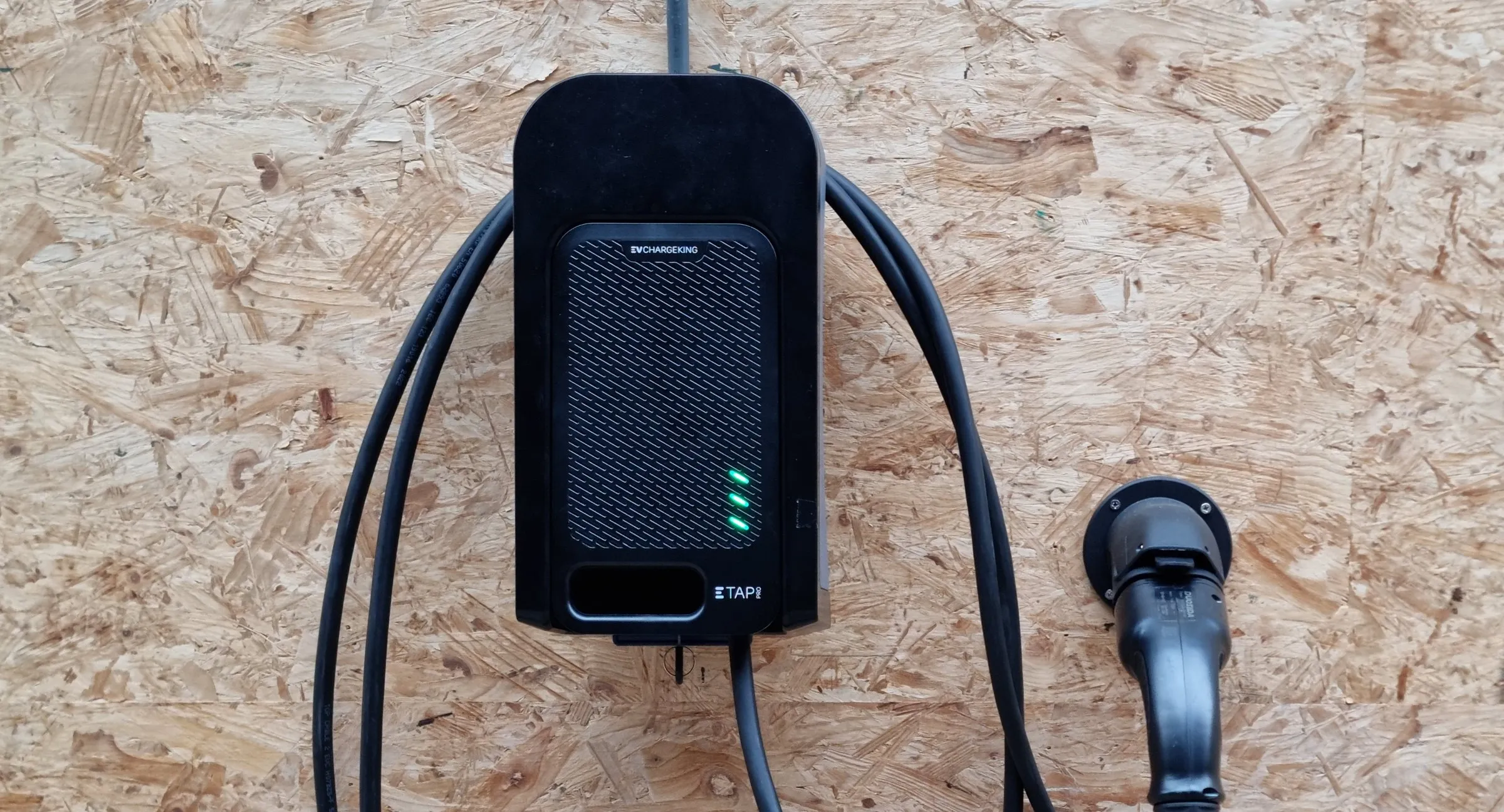 ETAPpro EV charger in its wall dock, with the charging cable looped around it and the connector in its holster