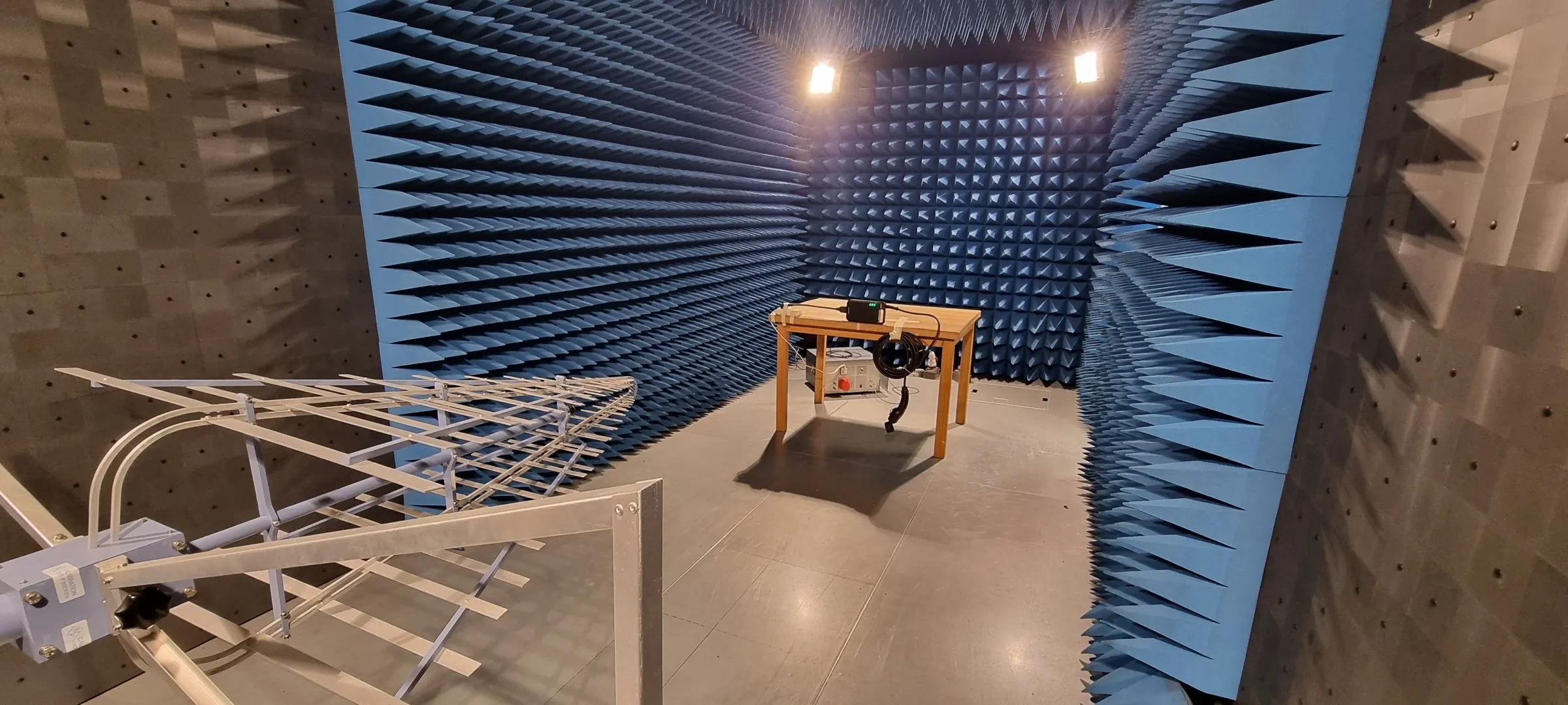 ETAPpro charger on a test table in an anechoic EMC chamber, with a measurement antenna in the foreground